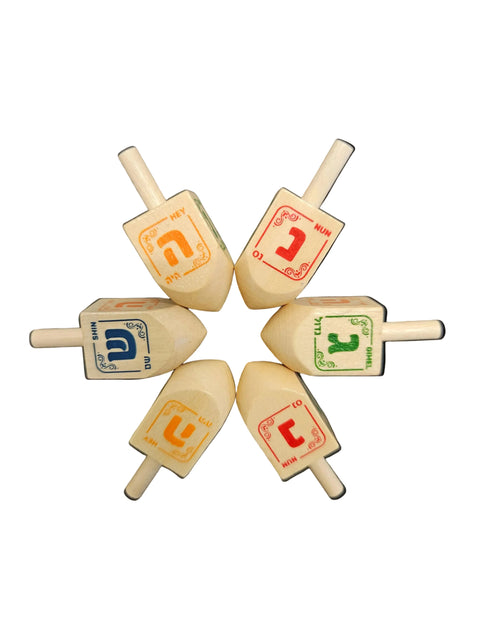 Set of six wooden dreidels with different letter designs on a white background